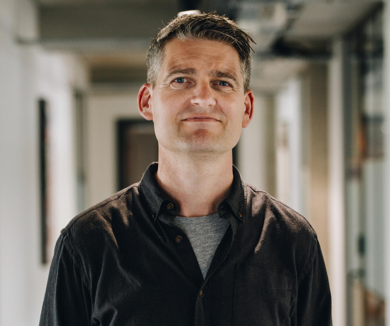 Ben Scoggins A head and shoulders image of a man in a casual shirt who is smiling and looking directly into the camera
